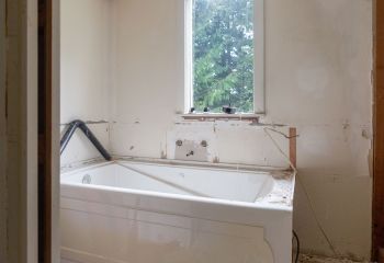 Close-up of rough-in plumbing and fresh drywall prep during San Fernando bathroom renovation.